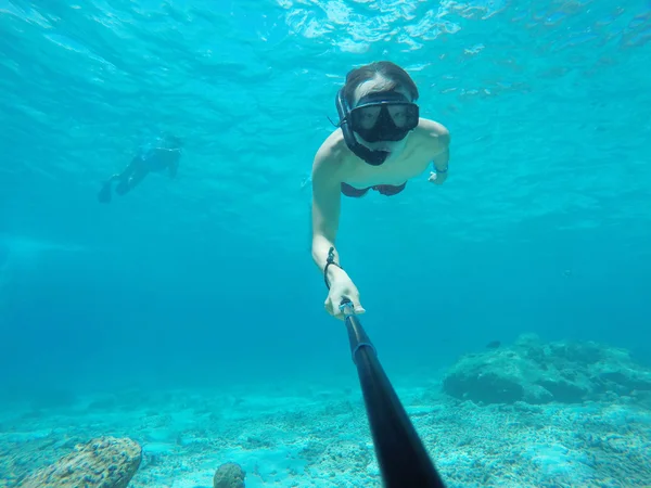 Underwater selfie shot with selfie stick. Deep blue sea. Wide angle shot.