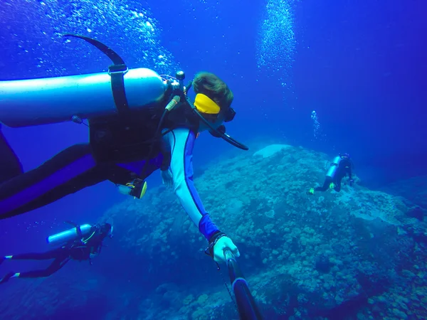 Underwater scuba diving selfie shot with selfie stick. Deep blue sea. Wide angle shot.