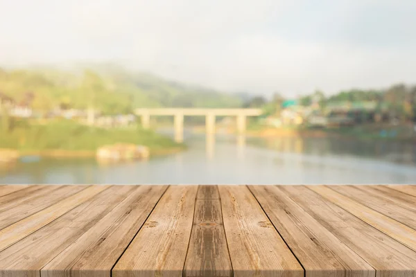 Wooden board empty table in front of blurred background. Perspective brown wood over blur wooden bridge - can be used mock up for display or montage your products. spring season. vintage filtered.