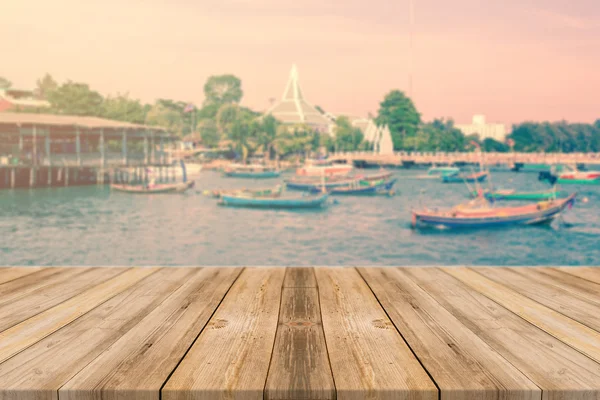 Wooden board empty table in front of blurred background. Perspective brown wood over blur boat in port - can be used for display or montage your products. vintage filtered image