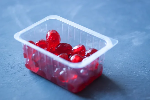 Canned cherries in plastic box on blue background