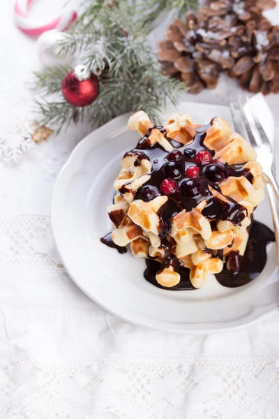 Waffles with chocolate sauce and winter berries for christmas
