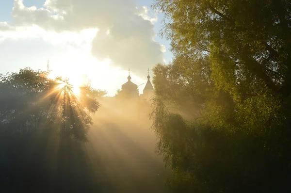 Misty morning and sun\'s rays on the temple