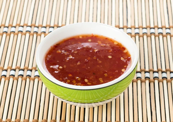 Bowl of chili sauce on wood background