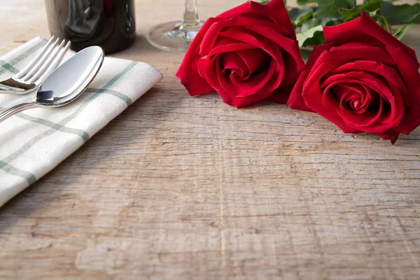 Red roses on dining table.  Valentine\'s Day, anniversary etc.