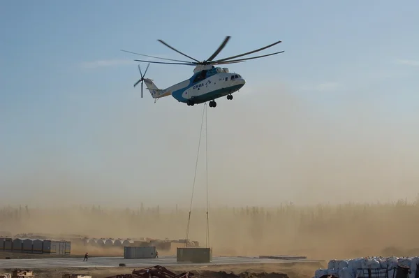 A large cargo helicopter Mi-26 takesoff from 20-foot container