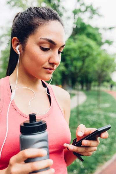 Woman using mobile phone after running