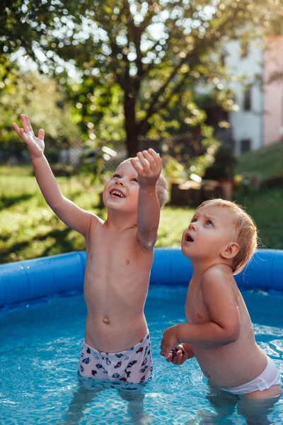 Happy brother and sister standing in the pool