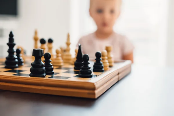 Little chess player thinking in the background