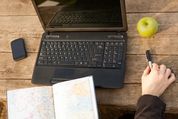 Man with Laptop and Map Planning a Trip Abroad