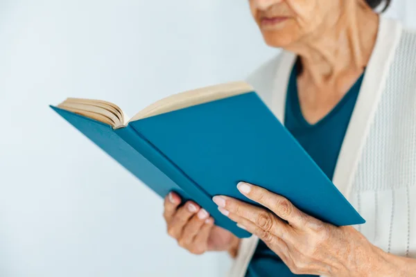 Closeup of old woman reading book