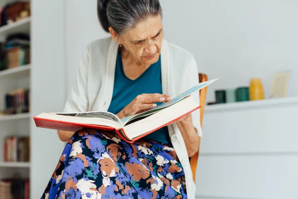 Old woman sitting and reading book