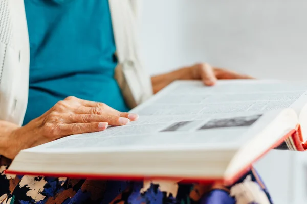 Closeup of old woman rading book