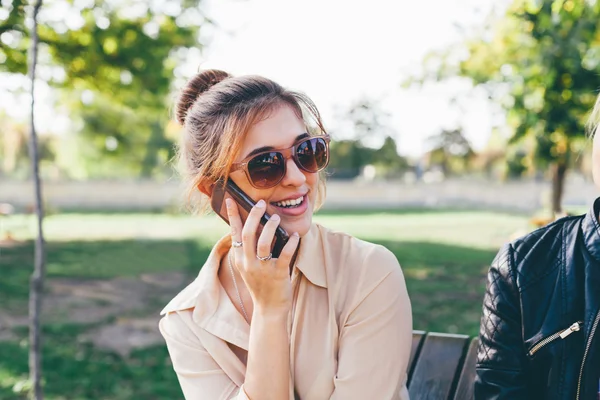 Smiling girl with sunglasses  talks on smart phone
