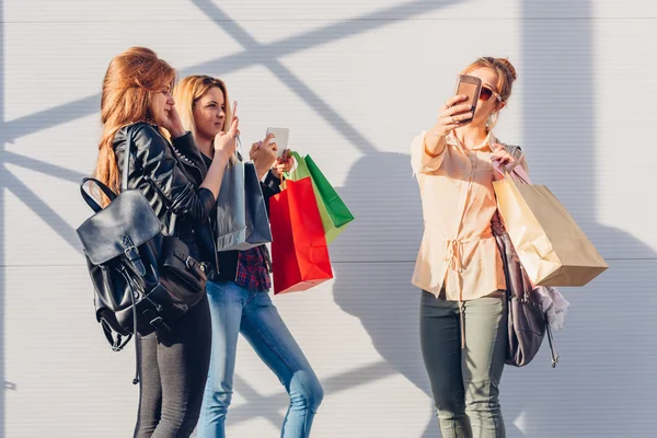 Girls use their mobile phones immediately after shopping