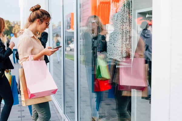 Girl using a mobile phone before entering the store