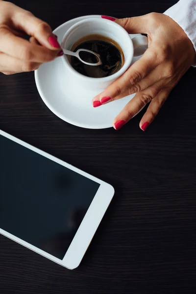 Top view of woman with tablet and cup of coffee