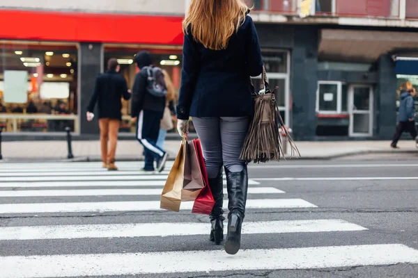 Woman crossing the street at the pedestrian crossing