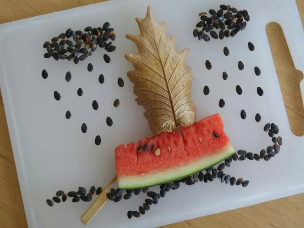 Composition of watermelon seeds, slice of watermelon and dry leaf