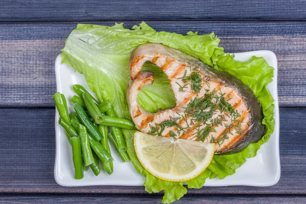 Plate of salmon fish with salad top view