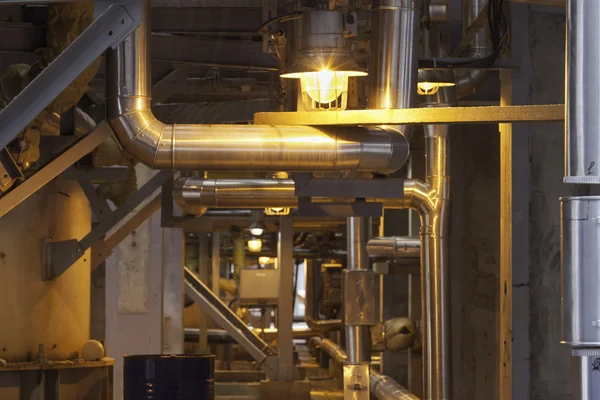 Hallway on the plant illuminated by lamp, pipe steel structure