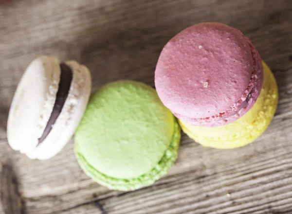 Colorful French macaroons on a dark  wooden background top view