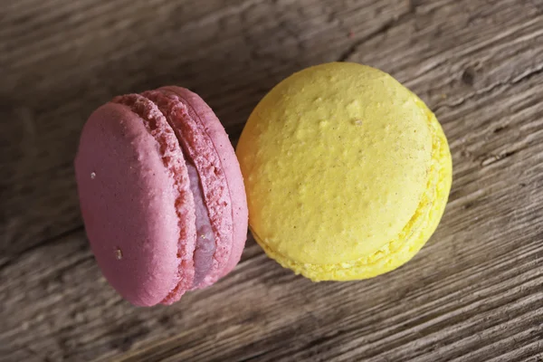 Colorful French macaroons on a dark  wooden background, selective focus