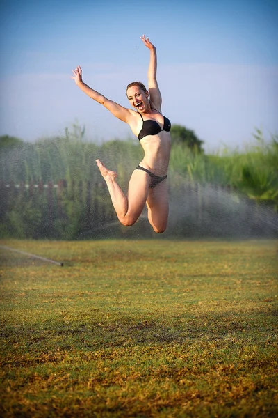 The beautiful blonde in a bathing suit jumping