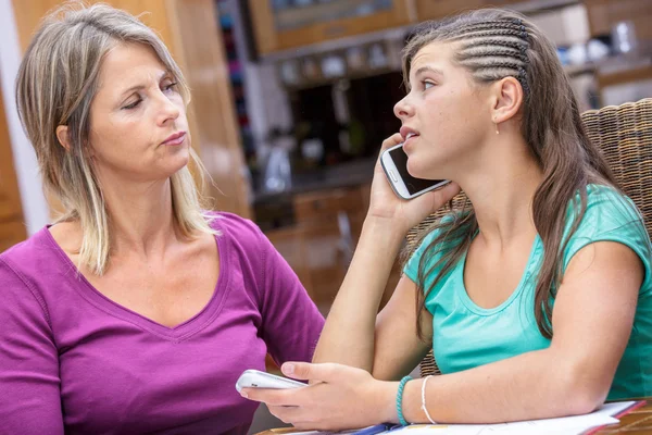 Closeup of a conflict between a mother and her daughter addict phone