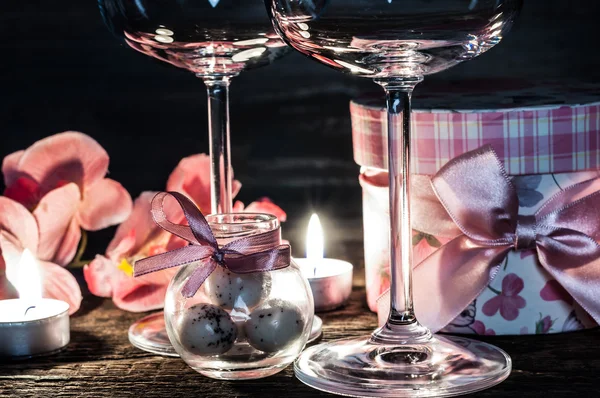 Wine glasses, gift and candles for romantic evening