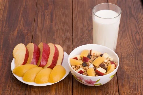 Muesli with peach, apple and a glass of milk