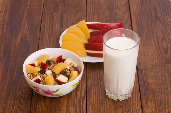 Muesli with peach, apple and a glass of milk