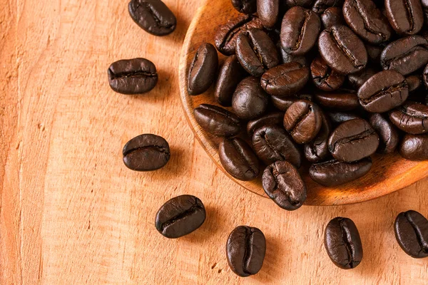 Coffee beans on wooden spoon.