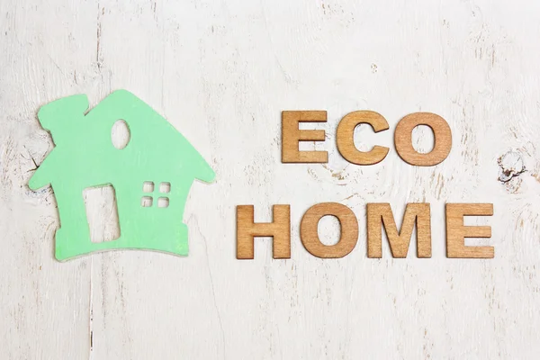 Word  eco home made of wooden letters and a green house on a whi