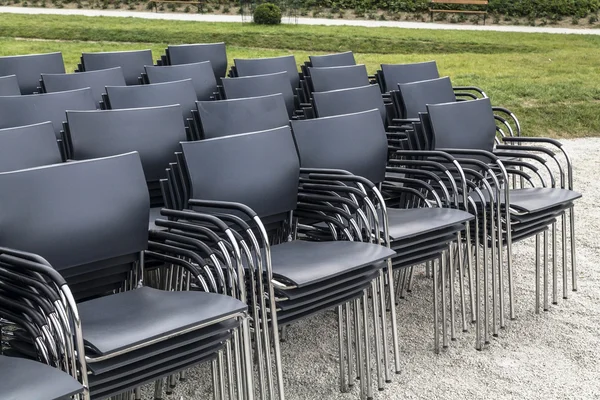 Stacked rows of black chairs