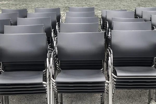 Stacked rows of black chairs