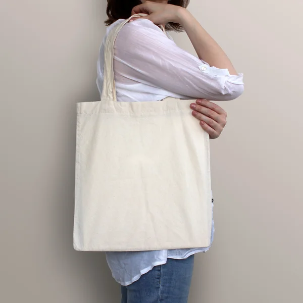 Girl is holding blank cotton eco bag, design mockup.
