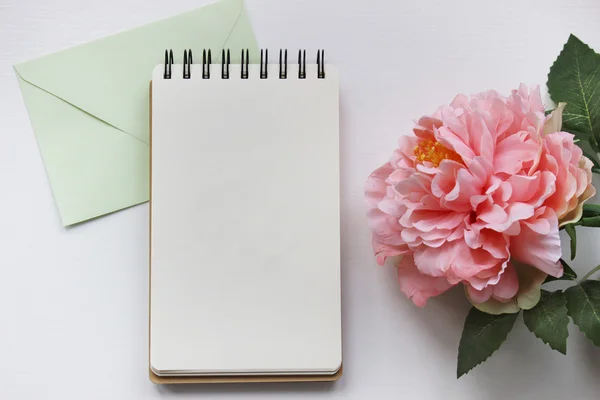 Mockup photography with pink peony, notebook and envelope