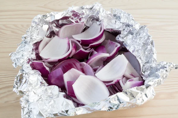 Peeled and chopped red onions in tin foil