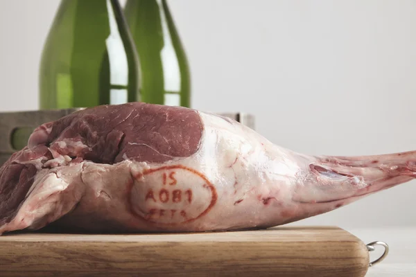 Lamb leg in front of two bottles isolated closeup