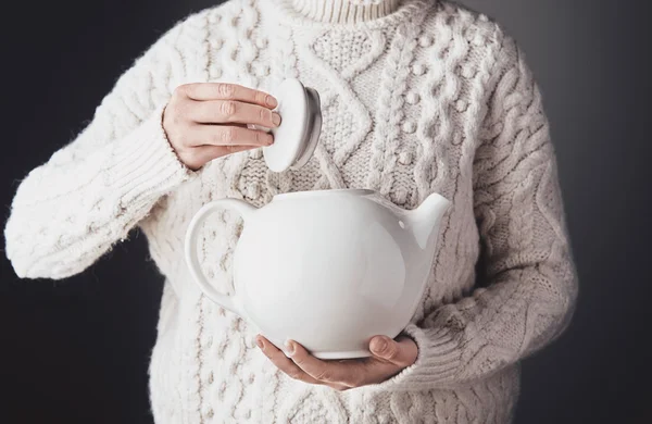 Adult woman hands hug teapot