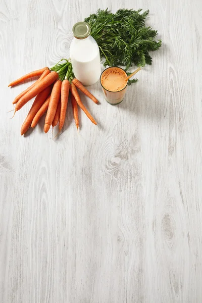 Carrot harvest lying near bottle