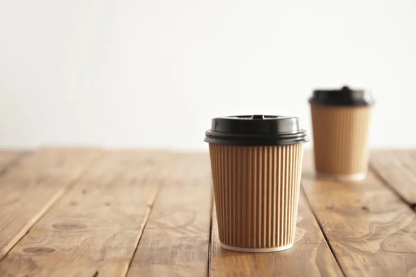Two carton paper cups with cap in row