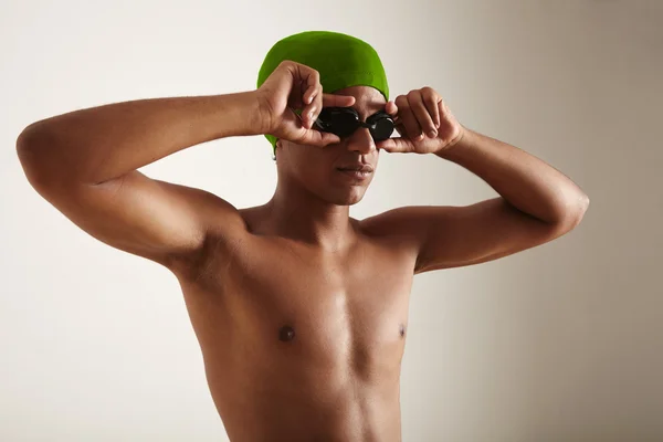 Young black swimmer in cap and goggles