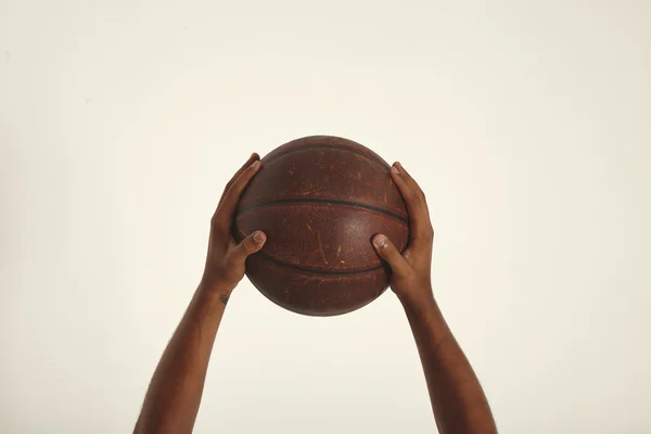 Two hands holding basketball