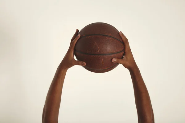 Two hands hold vintage basketball
