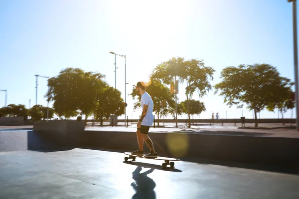 Longboarder in a sunlit skate park skating away