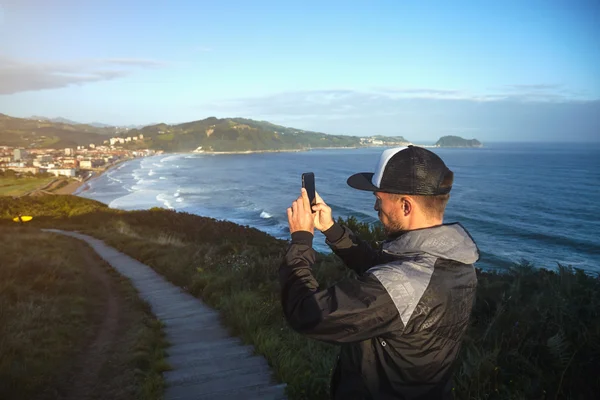 Adventurer takes a photo of  seaside town