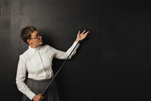 Female teacher with pointer near chalkboard