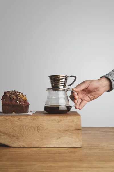 Chocolate cake with drip coffee maker in barista hand